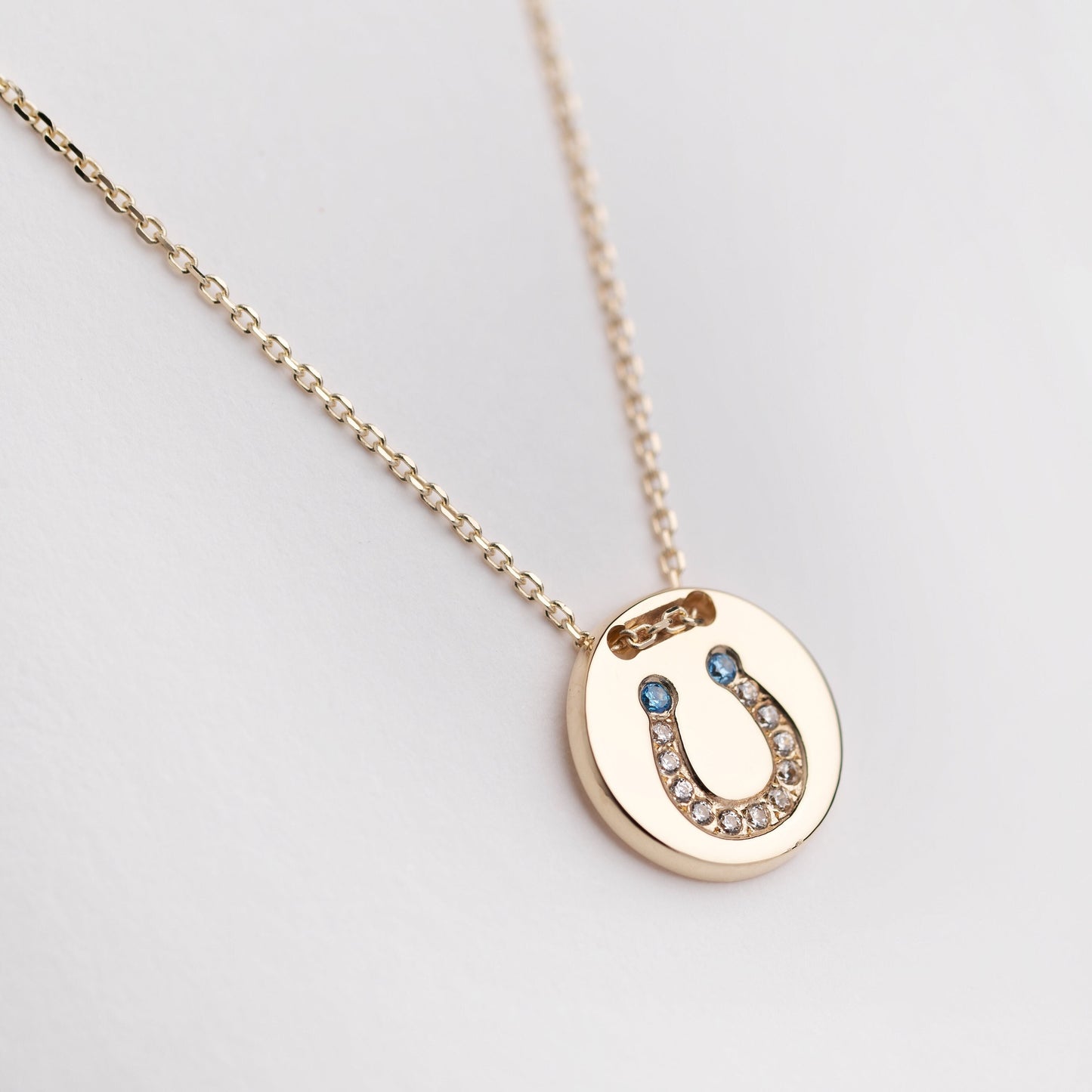 coin necklace in 14k gold with paved horseshoe