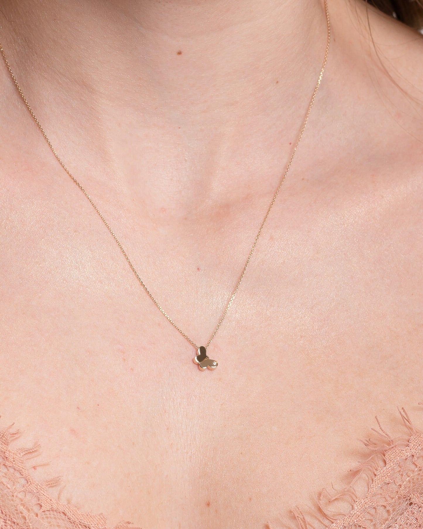 14K Gold Butterfly Necklace with a diamond worn by a model 