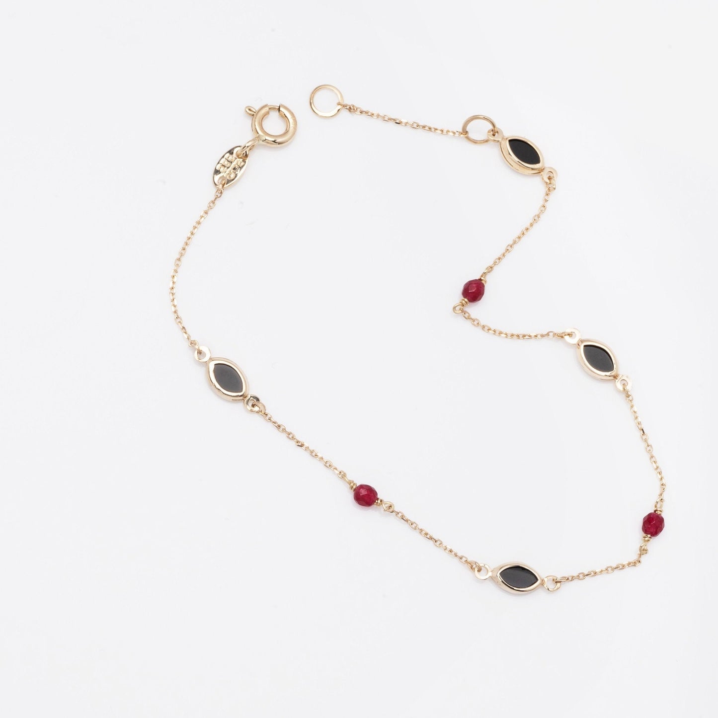 a 14k gold station bracelet with onyx and tourmaline