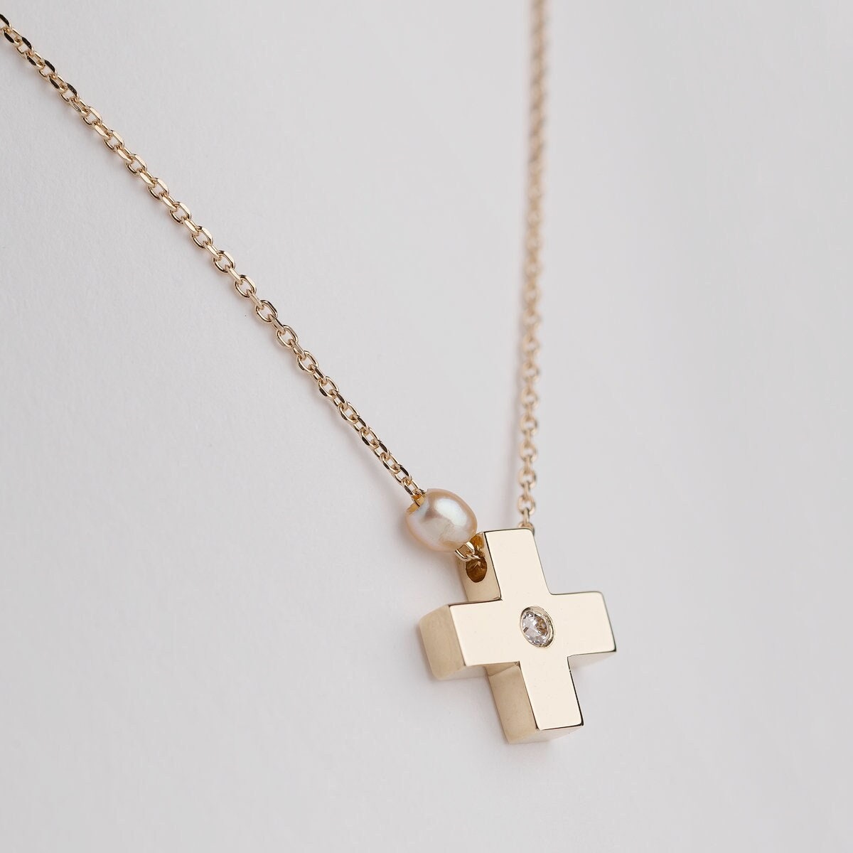 small diamond cross necklace with a small pearl in 14k yellow gold for women 