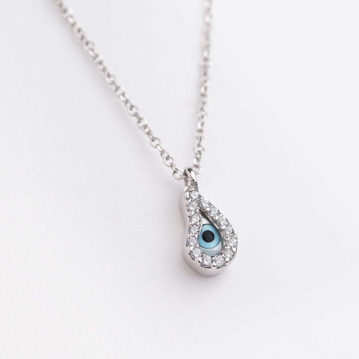 Mother of Pearl Evil Eye Necklace featuring a paisley design and cubic zirconia stones set in 14k gold, designed for women.