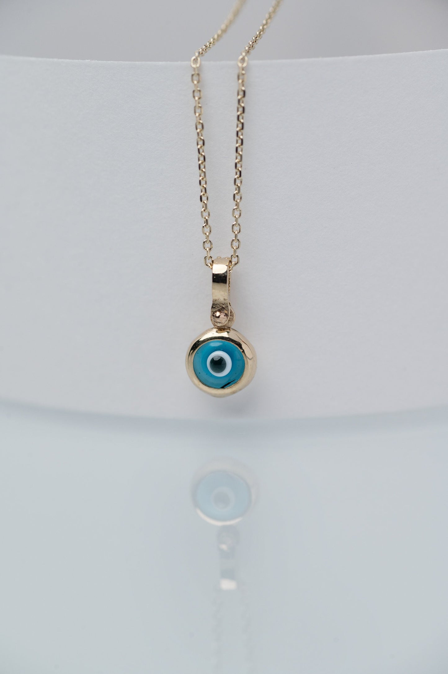 Murano glass evil eye necklace in 14k gold with cubic zirconia stones on the loop for women.