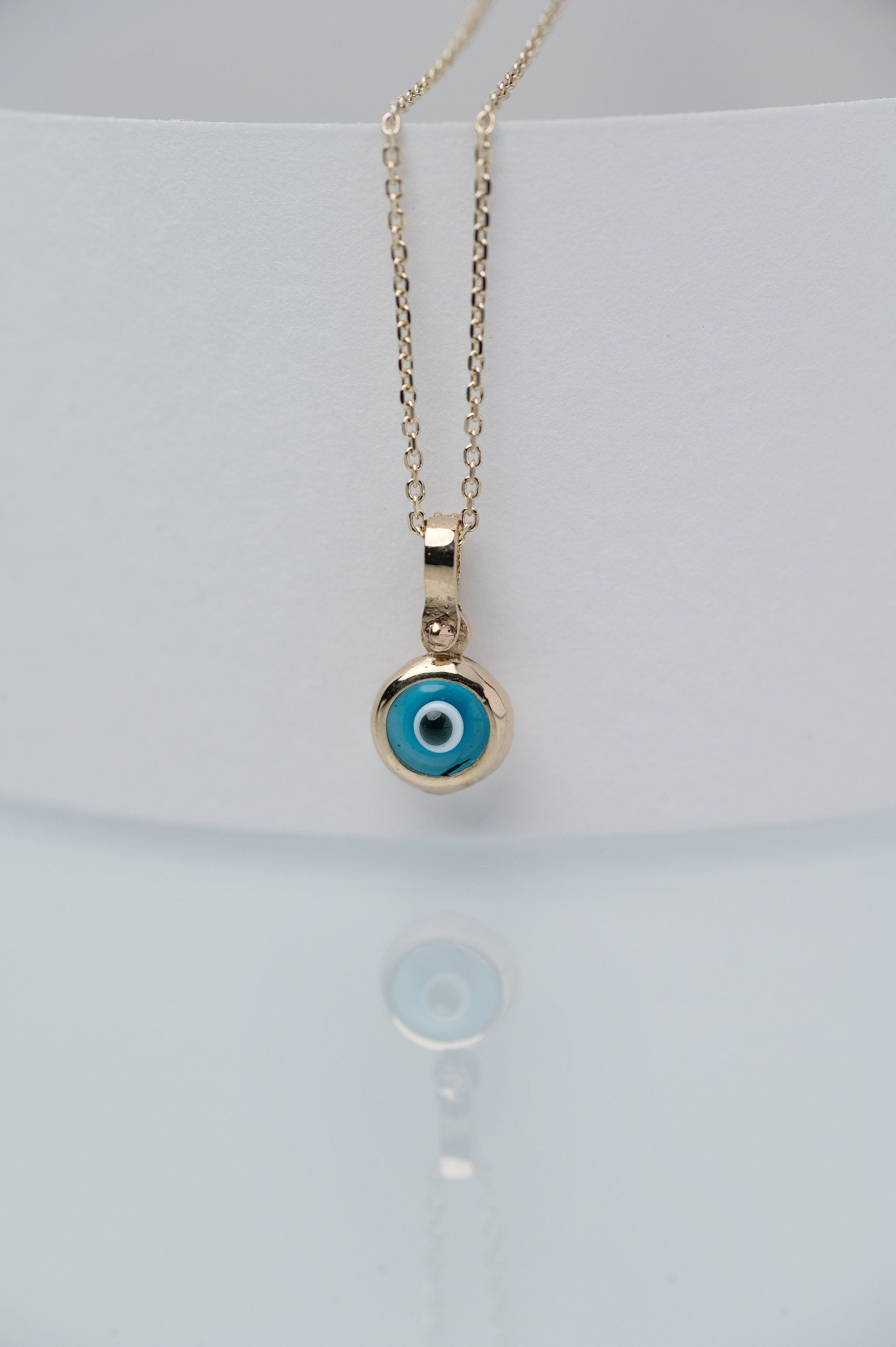 Murano glass evil eye necklace in 14k gold with cubic zirconia stones on the loop for women.