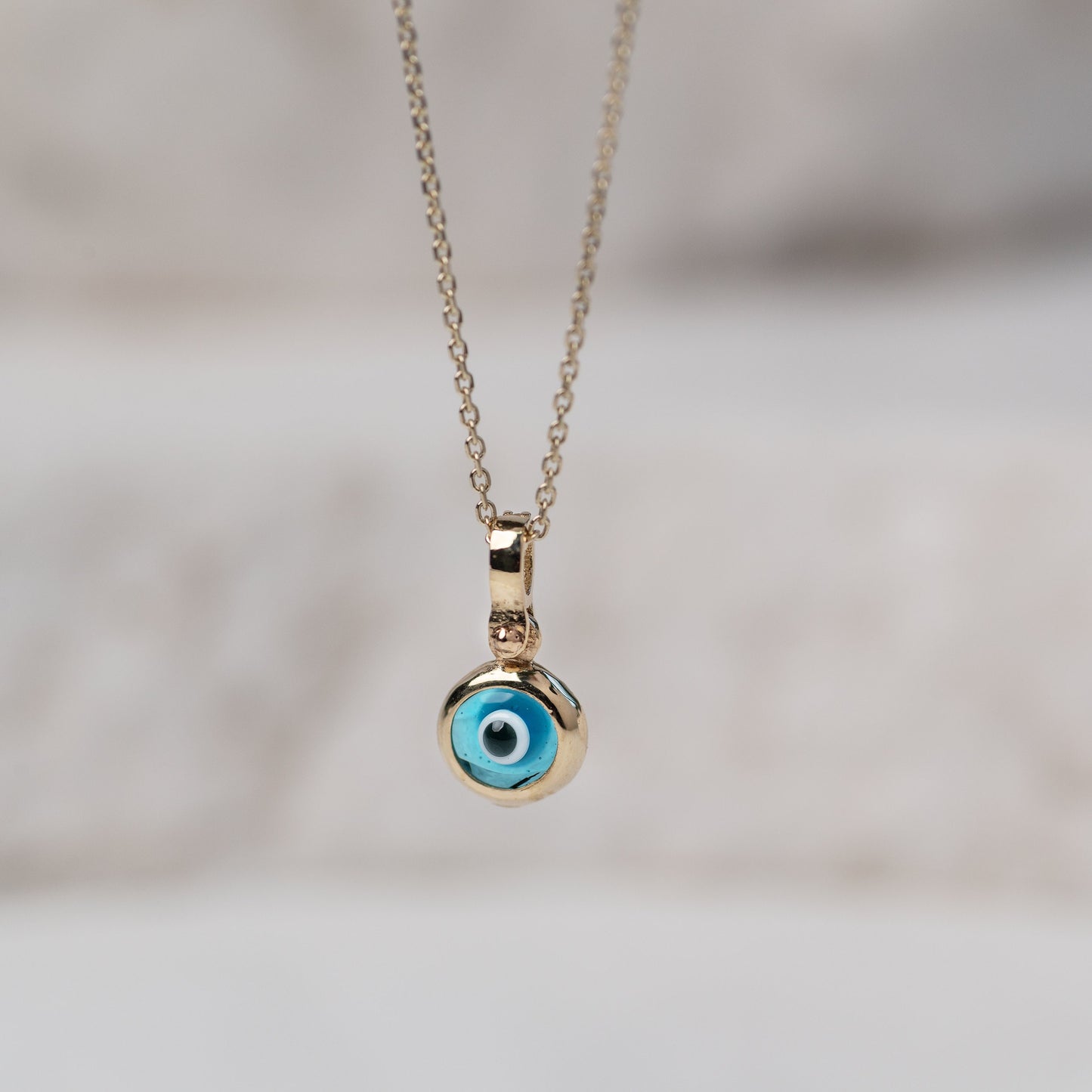 Murano glass evil eye necklace in 14k gold with cubic zirconia stones on the loop for women.