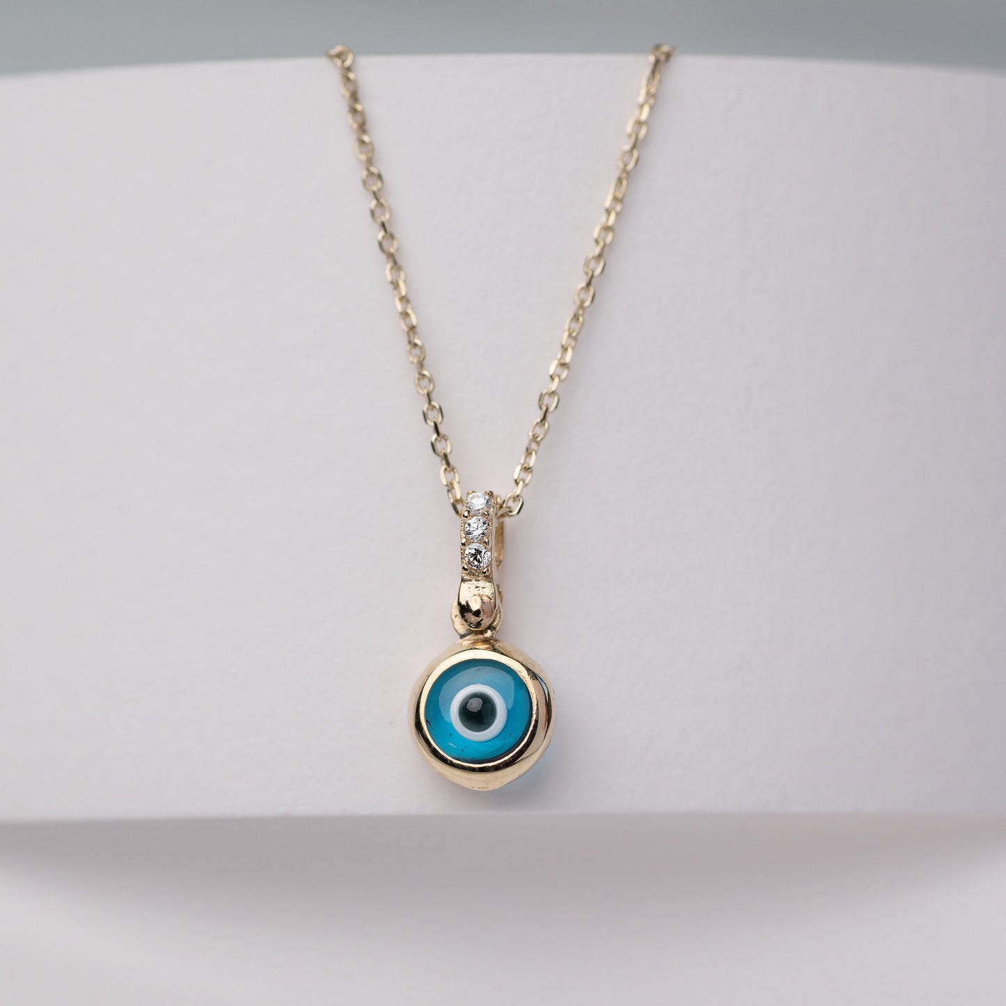 Murano glass evil eye necklace in 14k gold with cubic zirconia stones on the loop for women.