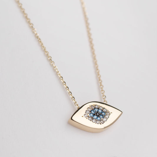 An oval-shaped evil eye necklace crafted in 14k gold and encrusted with cubic zirconia stones.