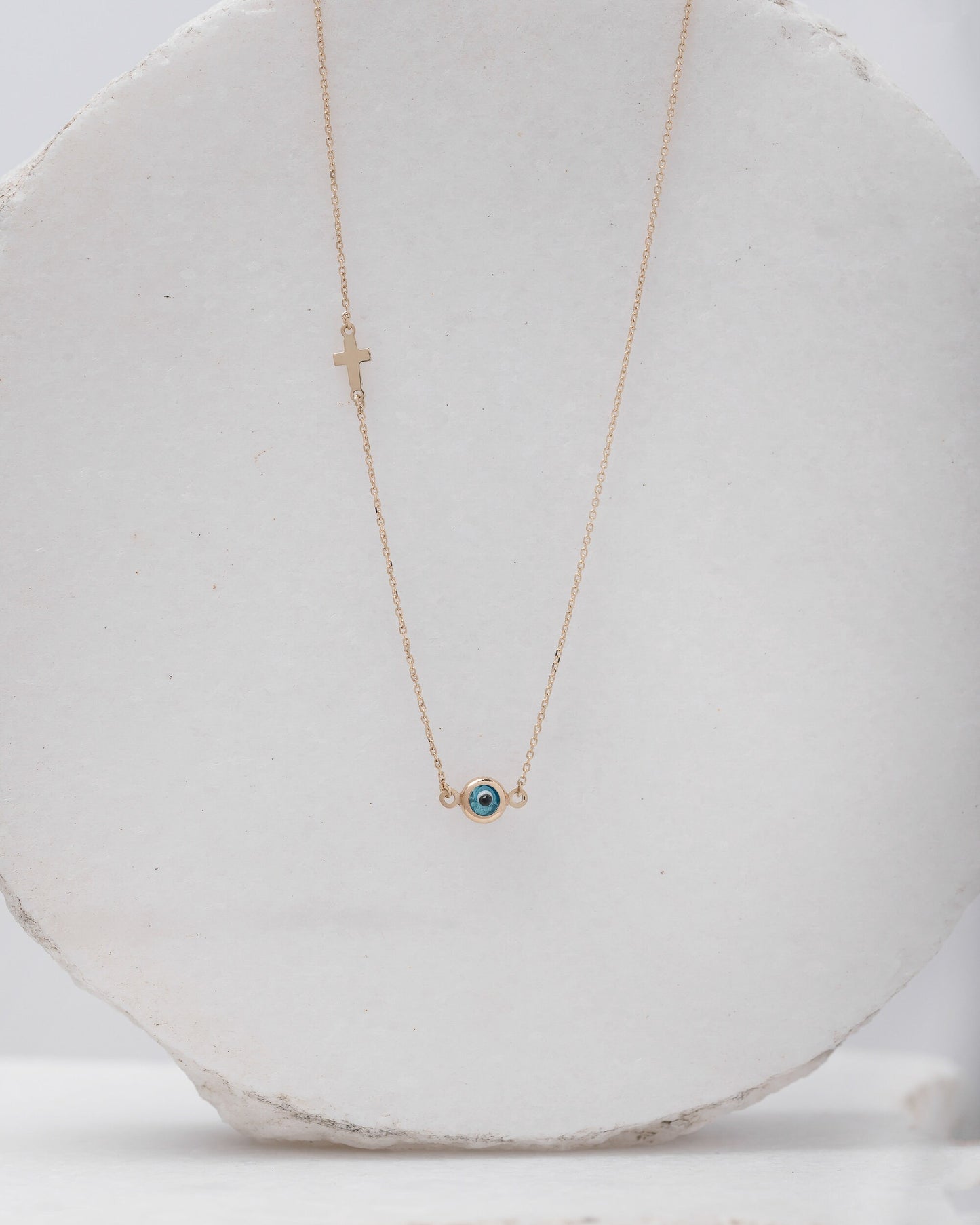 Murano glass double-sided evil eye necklace in 14k gold with a small side cross. 