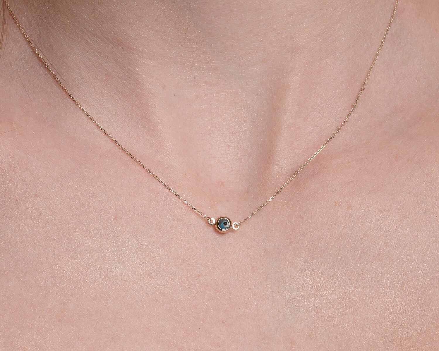 Murano glass double-sided evil eye necklace in 14k gold worn by a model 