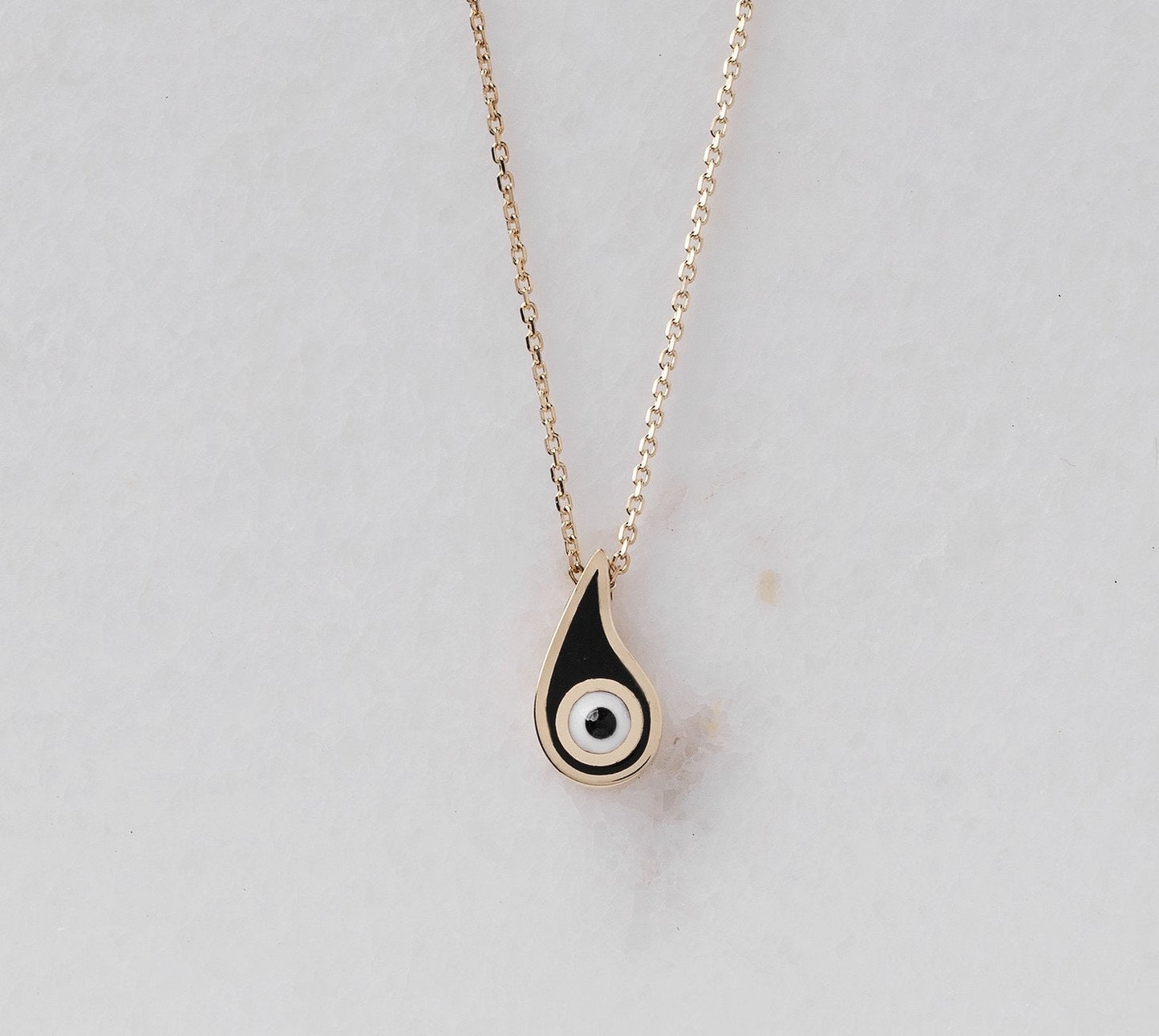 Evil Eye Paisley Necklace for women, crafted in 14k gold with black enamel detailing.