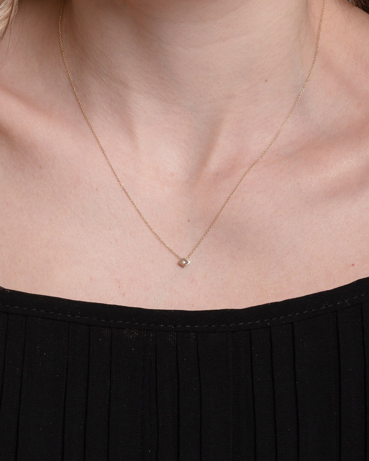 rhombus diamond necklace in 18k gold worn by a model 