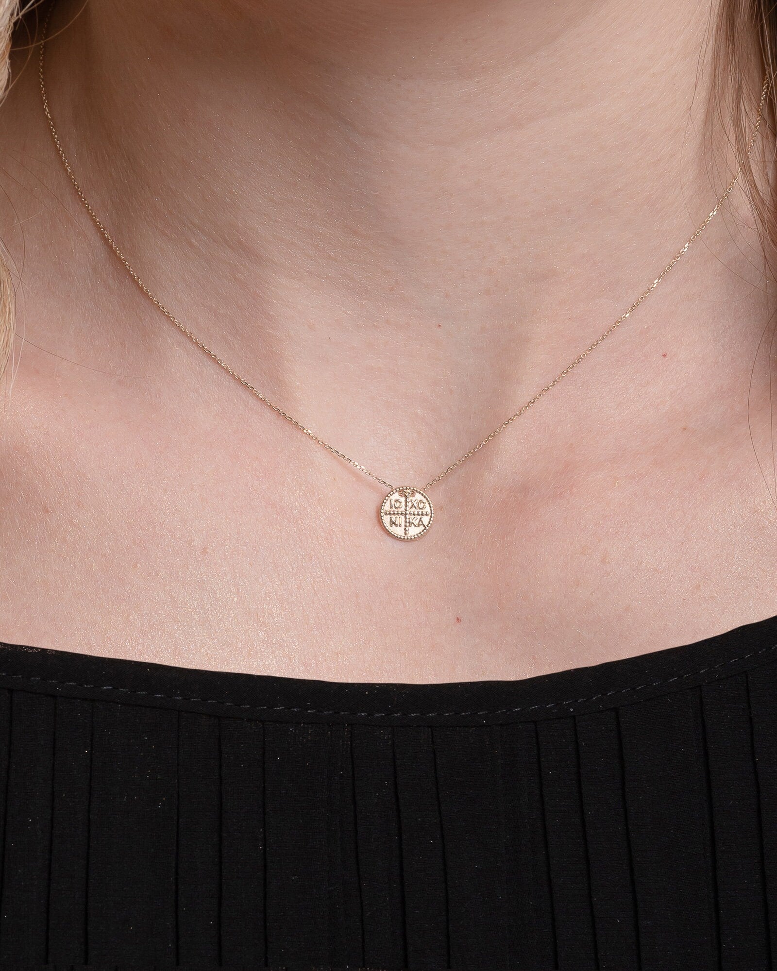 christian coin necklace in 14k yellow gold for women worn by a model 