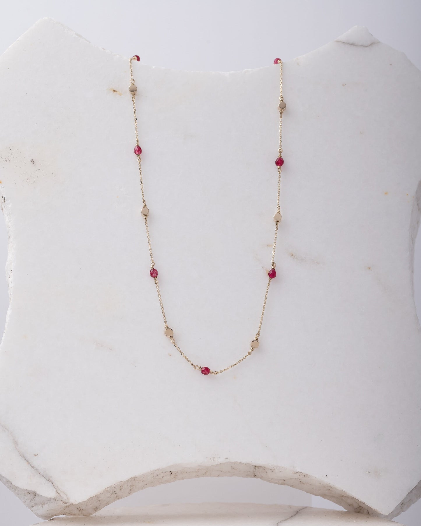 Station necklace featuring gold beads and tourmaline stones set in 14k gold.