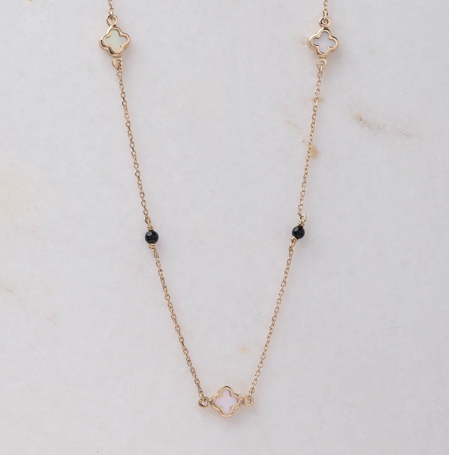 Mother-of-pearl clover necklace with onyx beads in 14k gold.