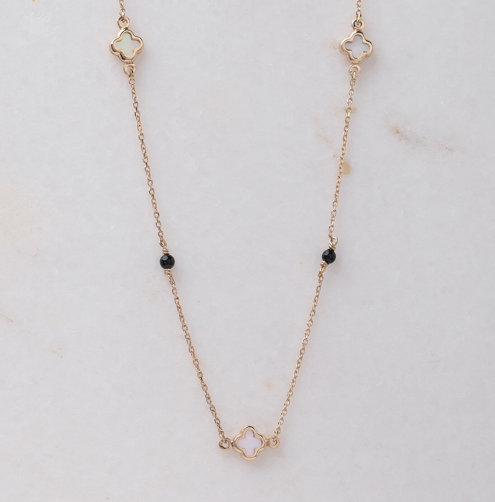 Mother-of-pearl clover necklace with onyx beads in 14k gold.