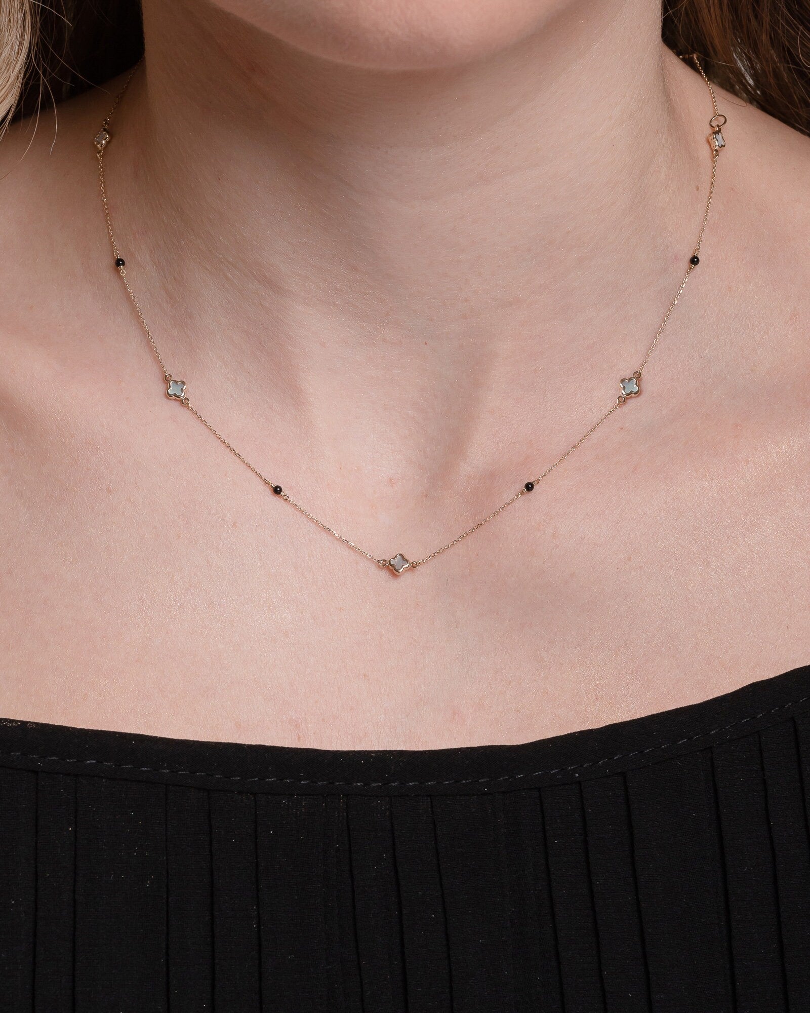 Mother-of-pearl clover necklace with onyx beads in 14k gold.