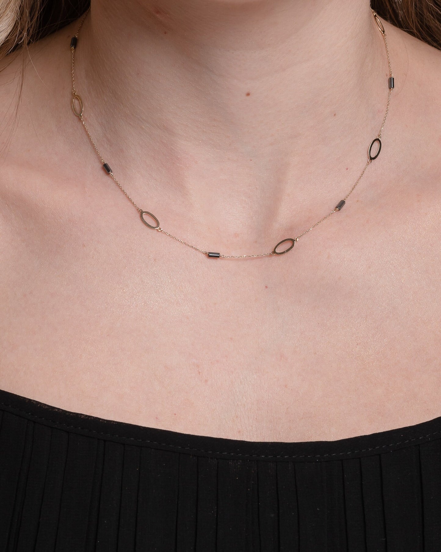 A station necklace adorned with oval patterns and bloodstone beads, crafted in 14k gold for women.