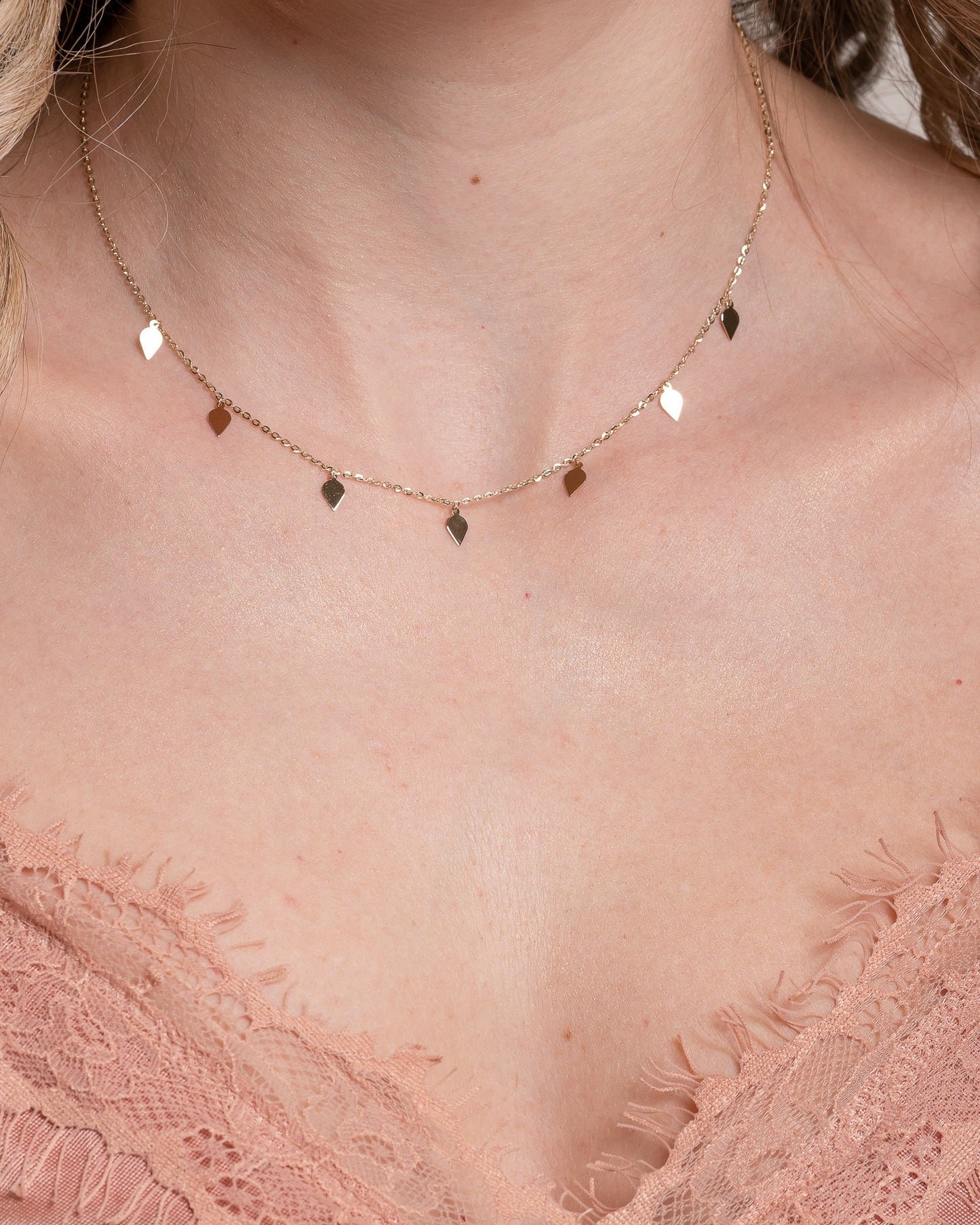 A station necklace featuring seven leaves crafted in 14k yellow gold for women.