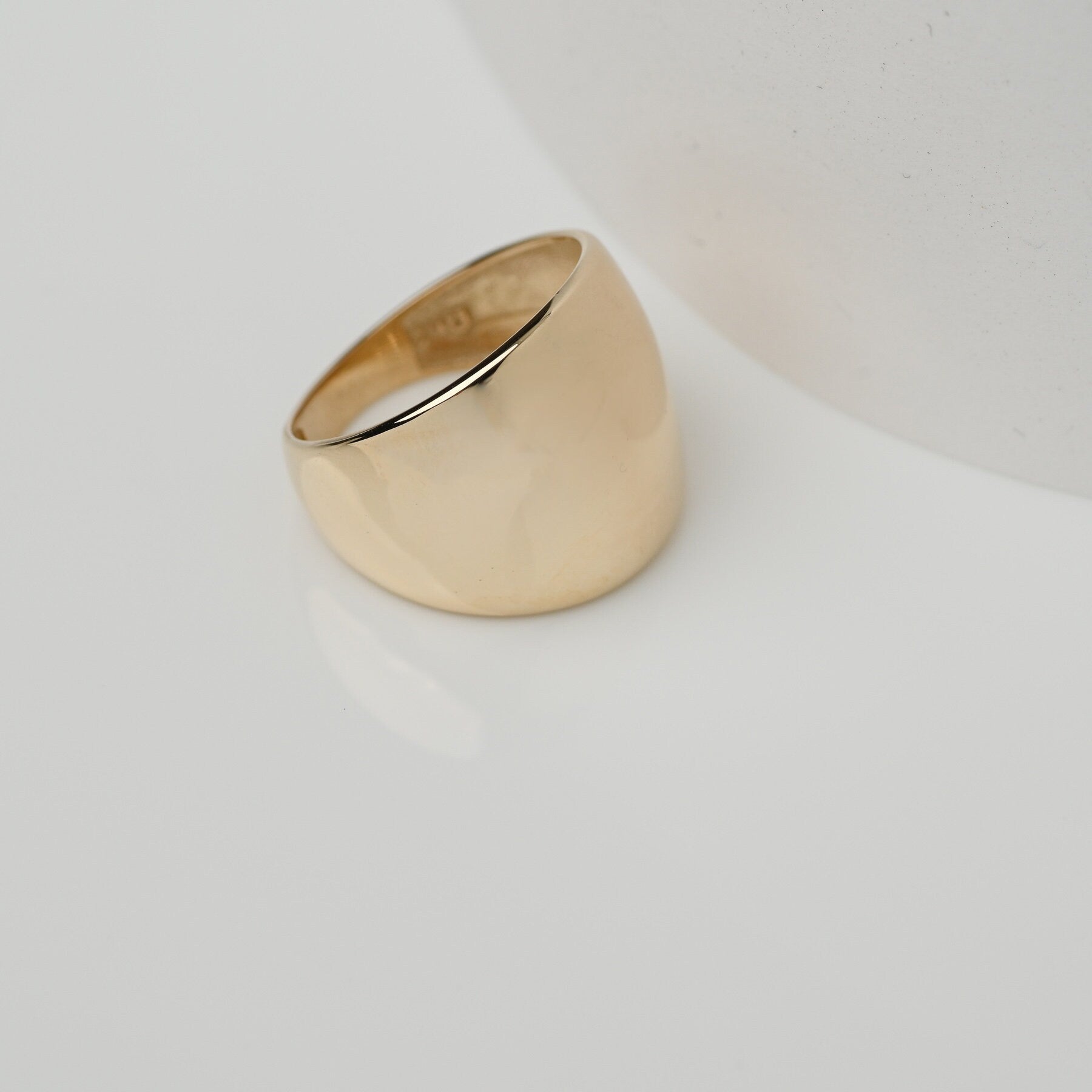 A large dome-shaped signet ring for women, crafted in 14k gold.