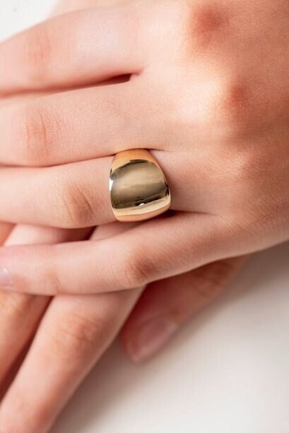 A large dome-shaped signet ring for women, crafted in 14k gold.