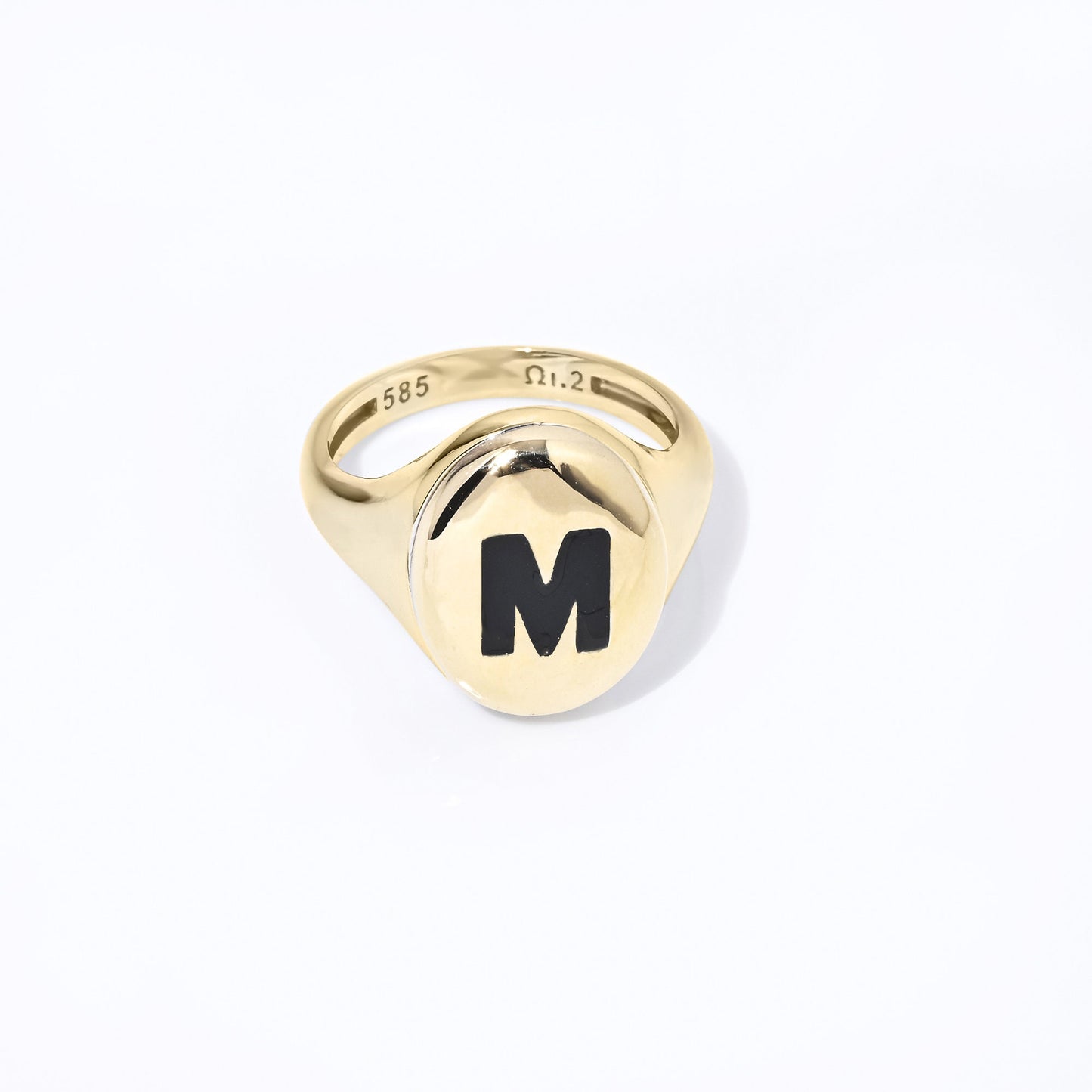 A  monogram signet ring in 14k gold with enamel accents for women.