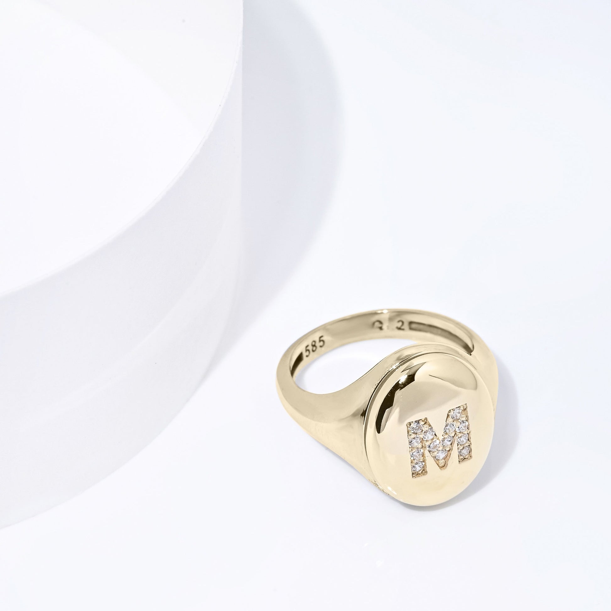 A two-tone monogrammed signet ring adorned with cubic zirconia stones, crafted in 14k gold for women.