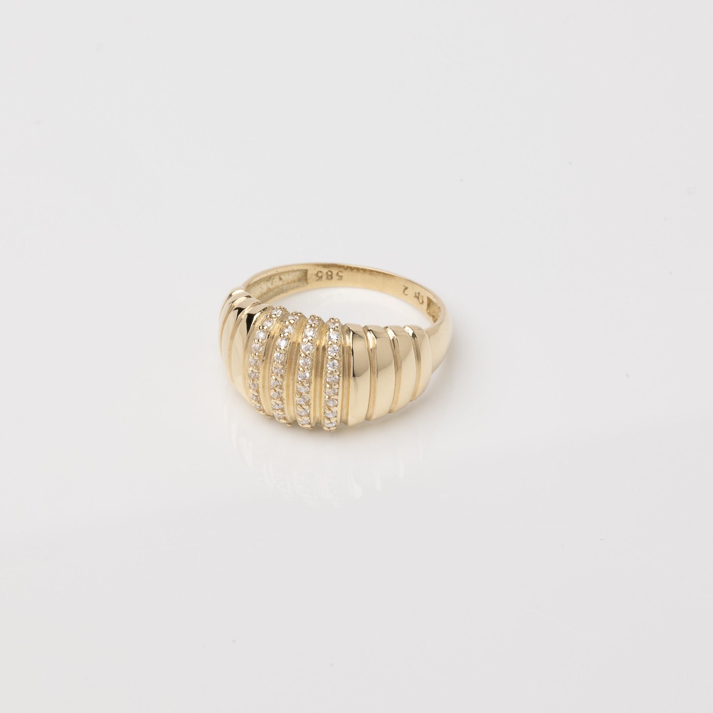 A Croissant Ring adorned with white cubic zirconia stones, set in 14k gold for women.