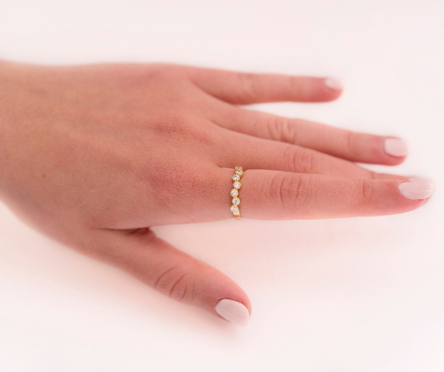 A half-eternity asymmetrical band crafted in 14k solid gold, adorned with white cubic zirconia stones.