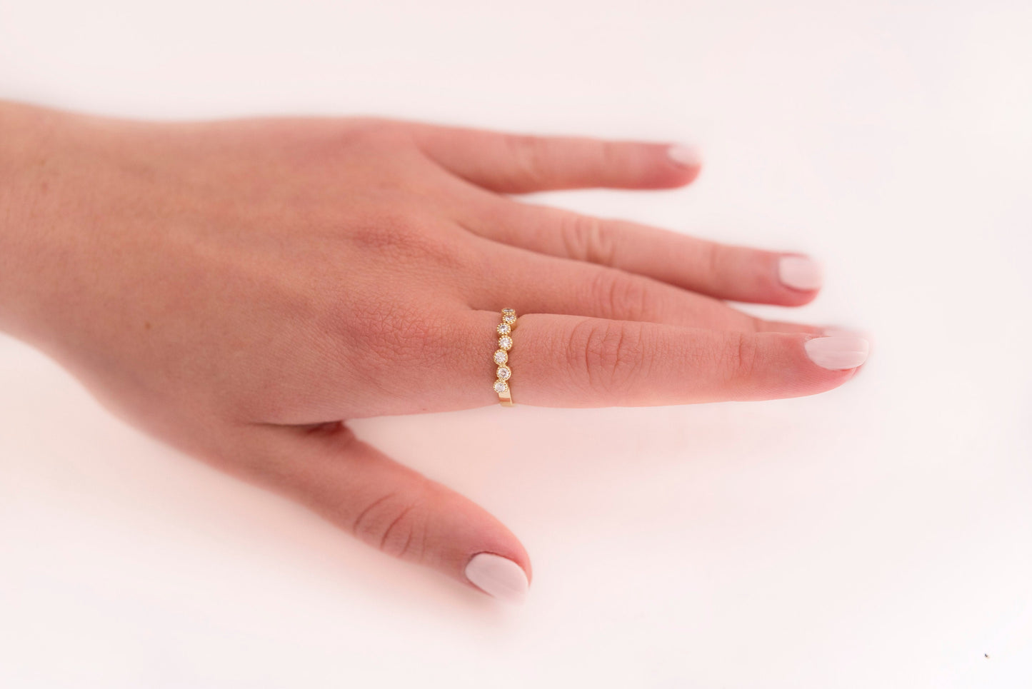 A half-eternity asymmetrical band crafted in 14k solid gold, adorned with white cubic zirconia stones.