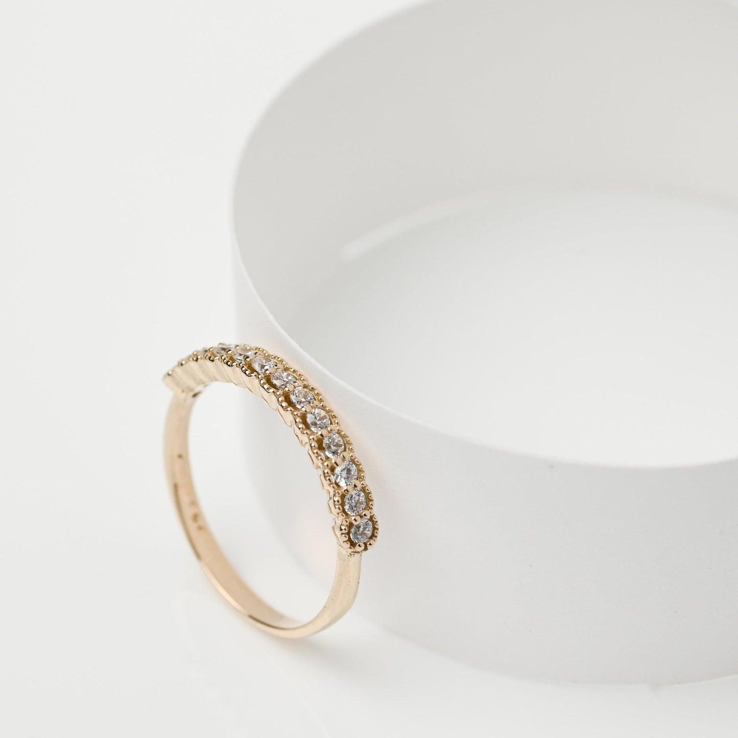 A women's half-eternity band ring featuring white cubic zirconia stones set in 14k gold.