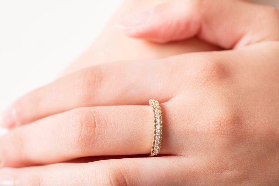 A women's half-eternity band ring featuring white cubic zirconia stones set in 14k gold.