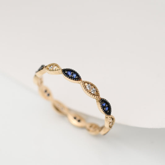 A full eternity band ring crafted in 14k gold, adorned with white and blue cubic zirconia stones.