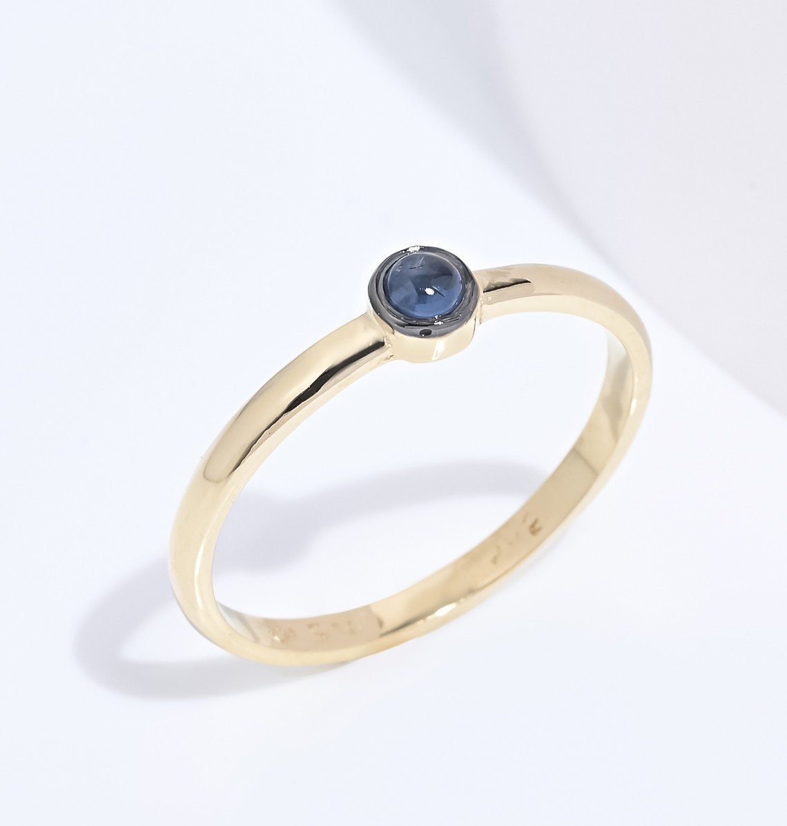 A handmade ring featuring a single birthstone in a bezel setting, crafted in 14k gold for women.