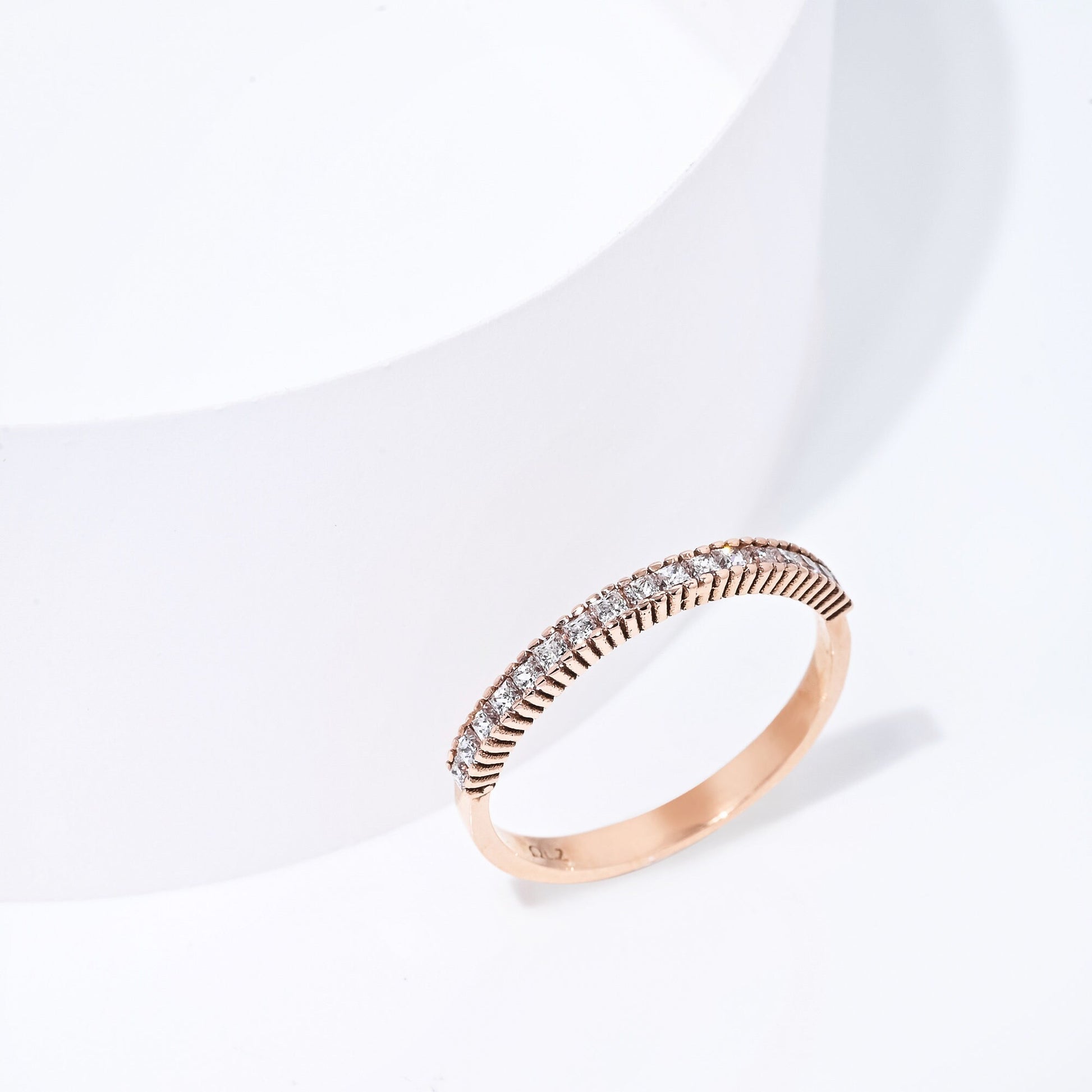 A half eternity band ring crafted in 14k solid gold, featuring white cubic zirconia stones in a prong setting.