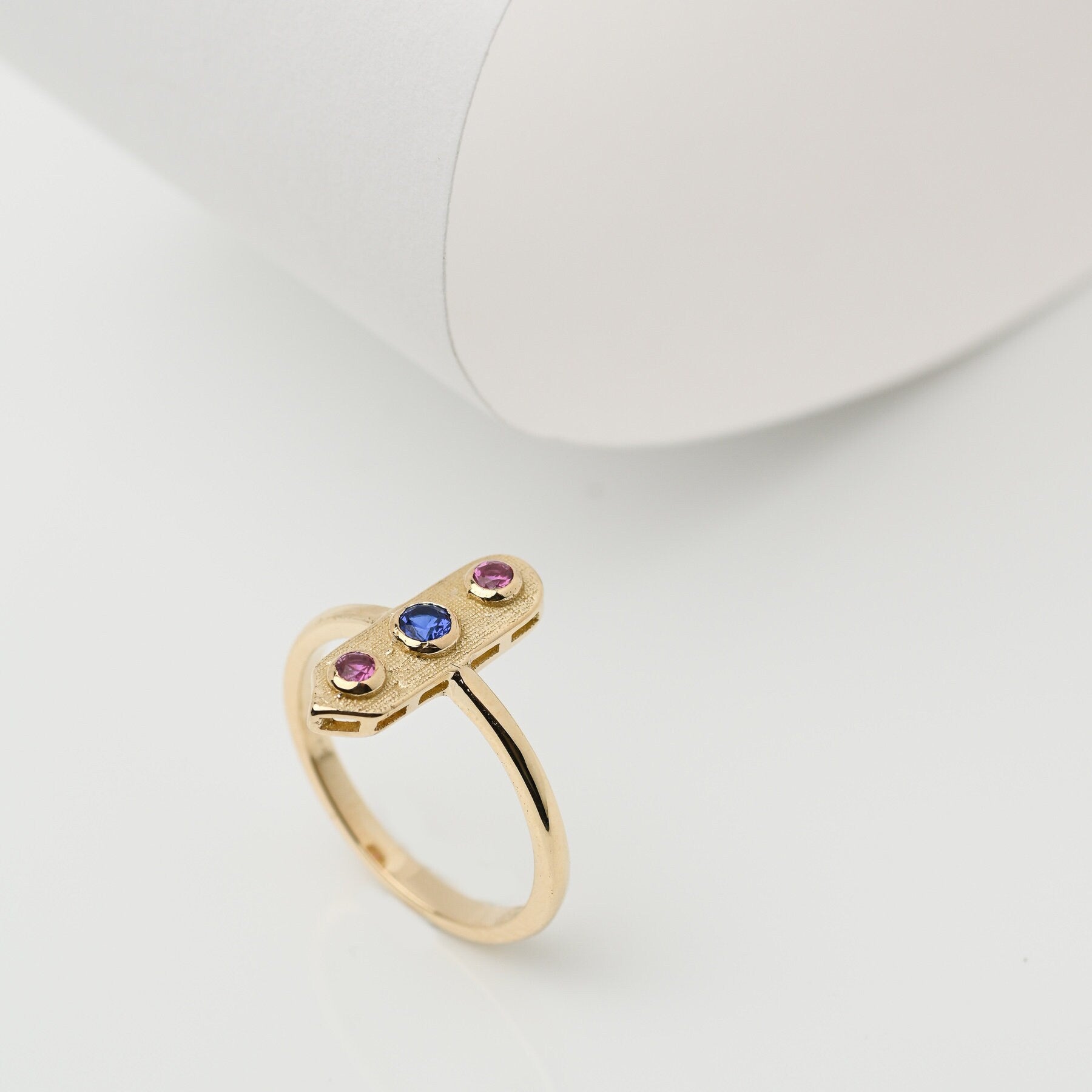 Handcrafted arrow-shaped gold ring with three gemstones set in 14k solid gold.