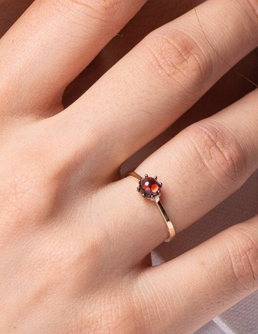 A natural garnet ring set in a 14k solid gold prong setting, designed for women.