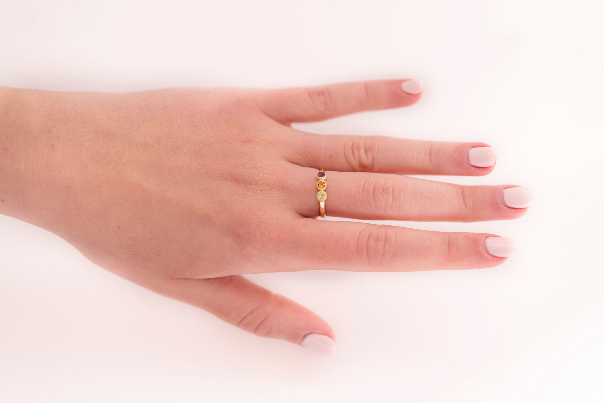 A handmade ring featuring three birthstones set in 14k solid gold with a prong setting.