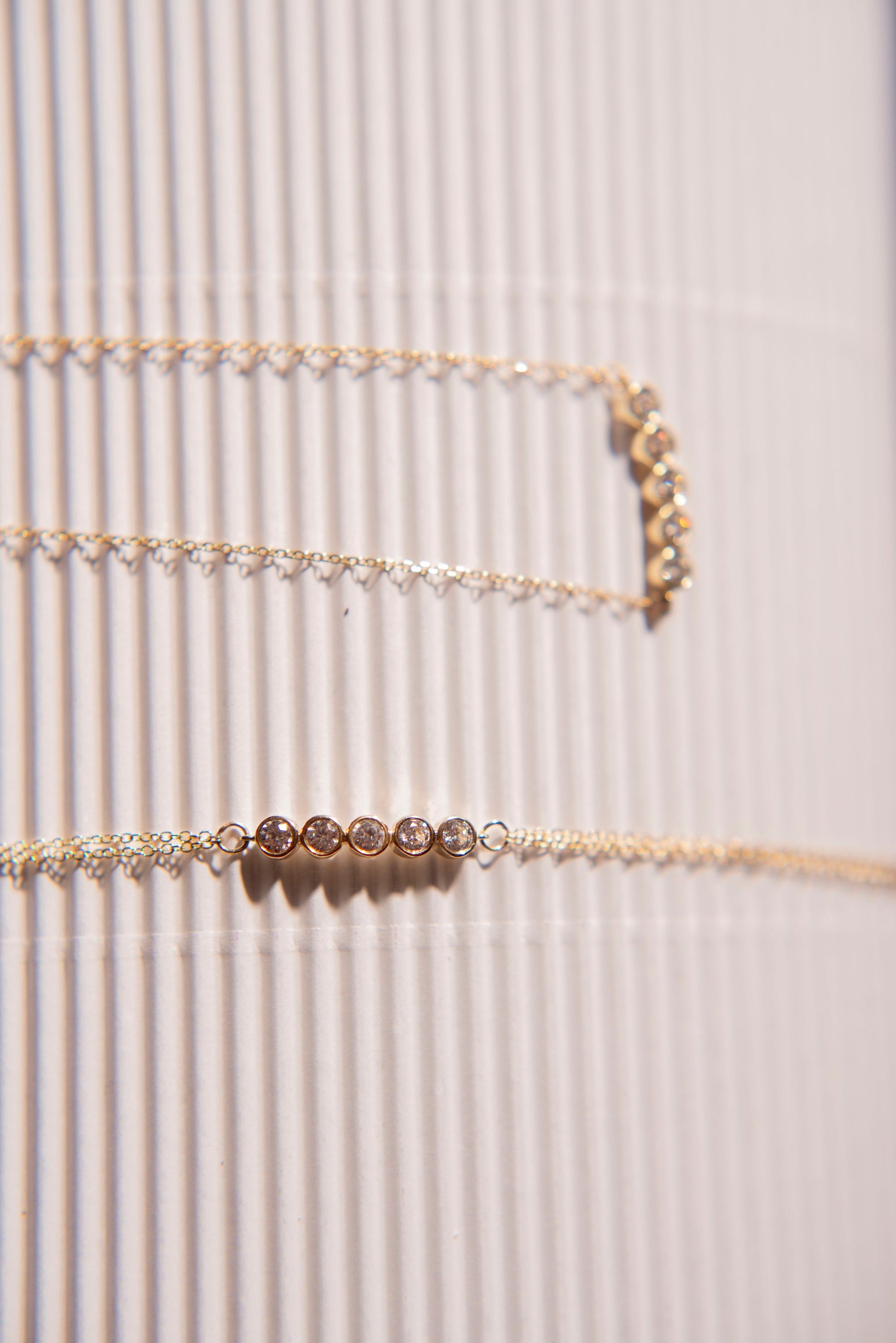 A 14k gold set featuring a birthstone bracelet and necklace, each adorned with five stones.