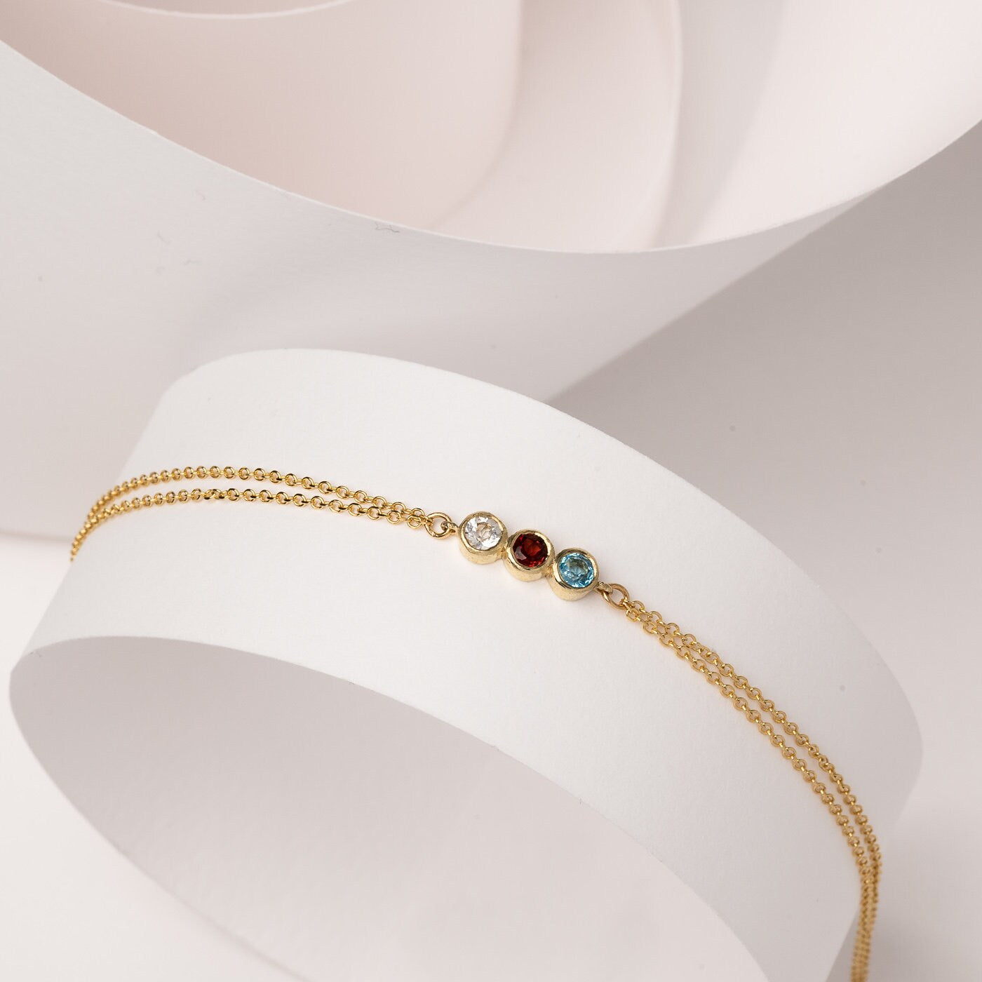 Handmade birthstone bracelet featuring three stones set in 14k gold, complemented by a double chain design for women.