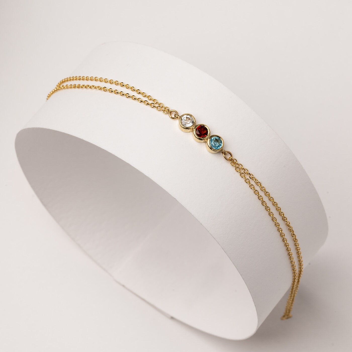 Handmade birthstone bracelet featuring three stones set in 14k gold, complemented by a double chain design for women.