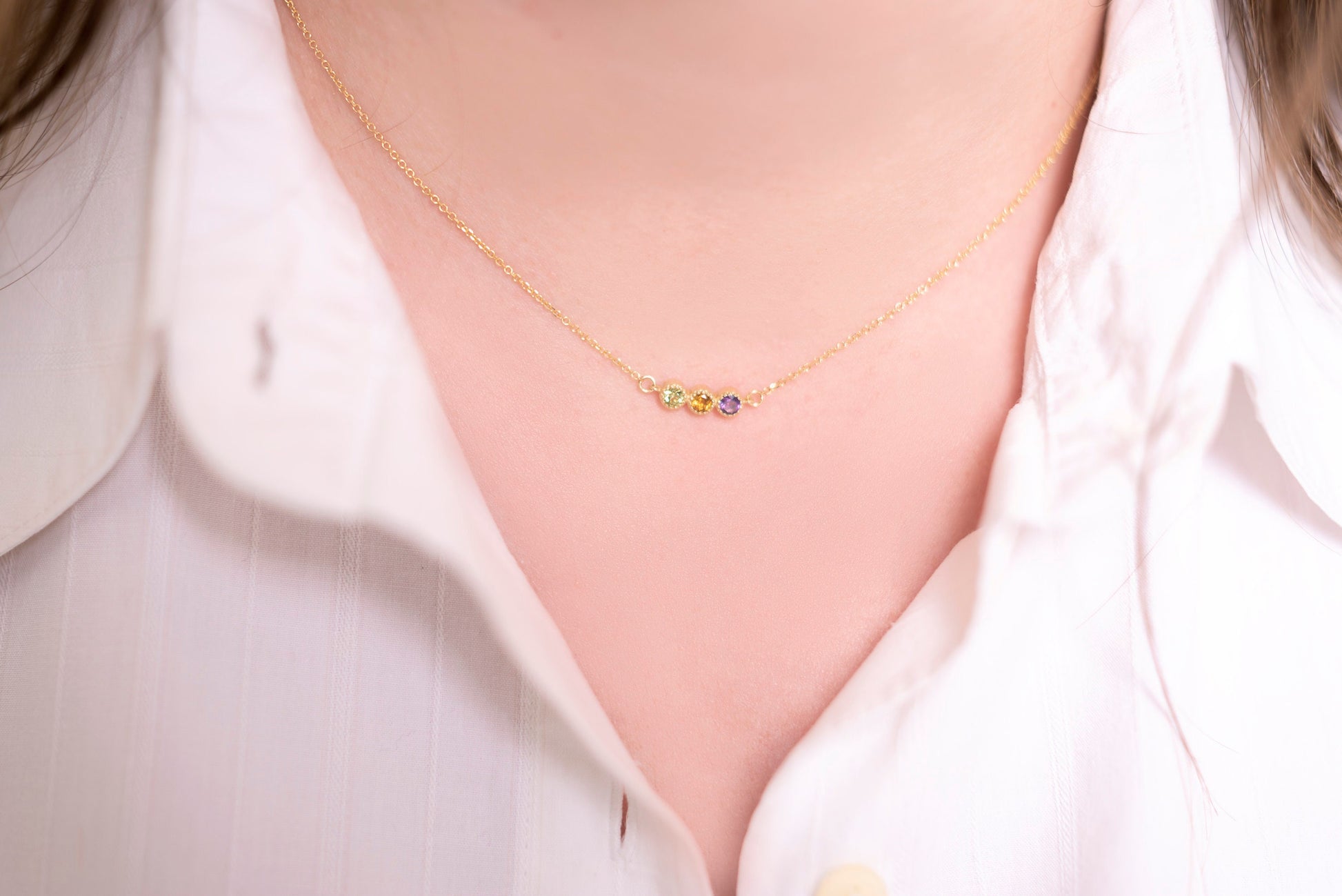 Handcrafted birthstone necklace in 14k gold, featuring three stones in a prong setting.