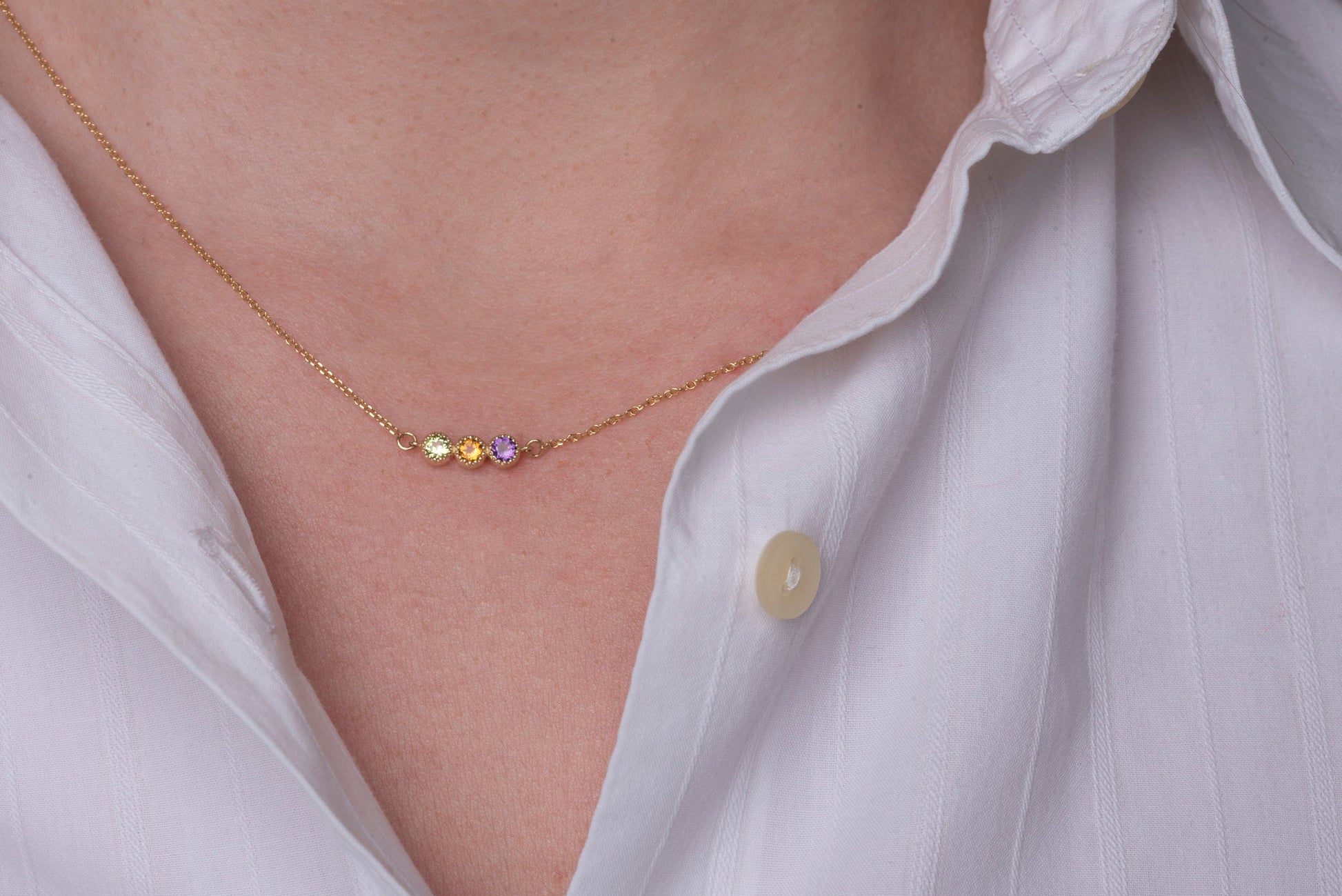 Handcrafted birthstone necklace in 14k gold, featuring three stones in a prong setting.