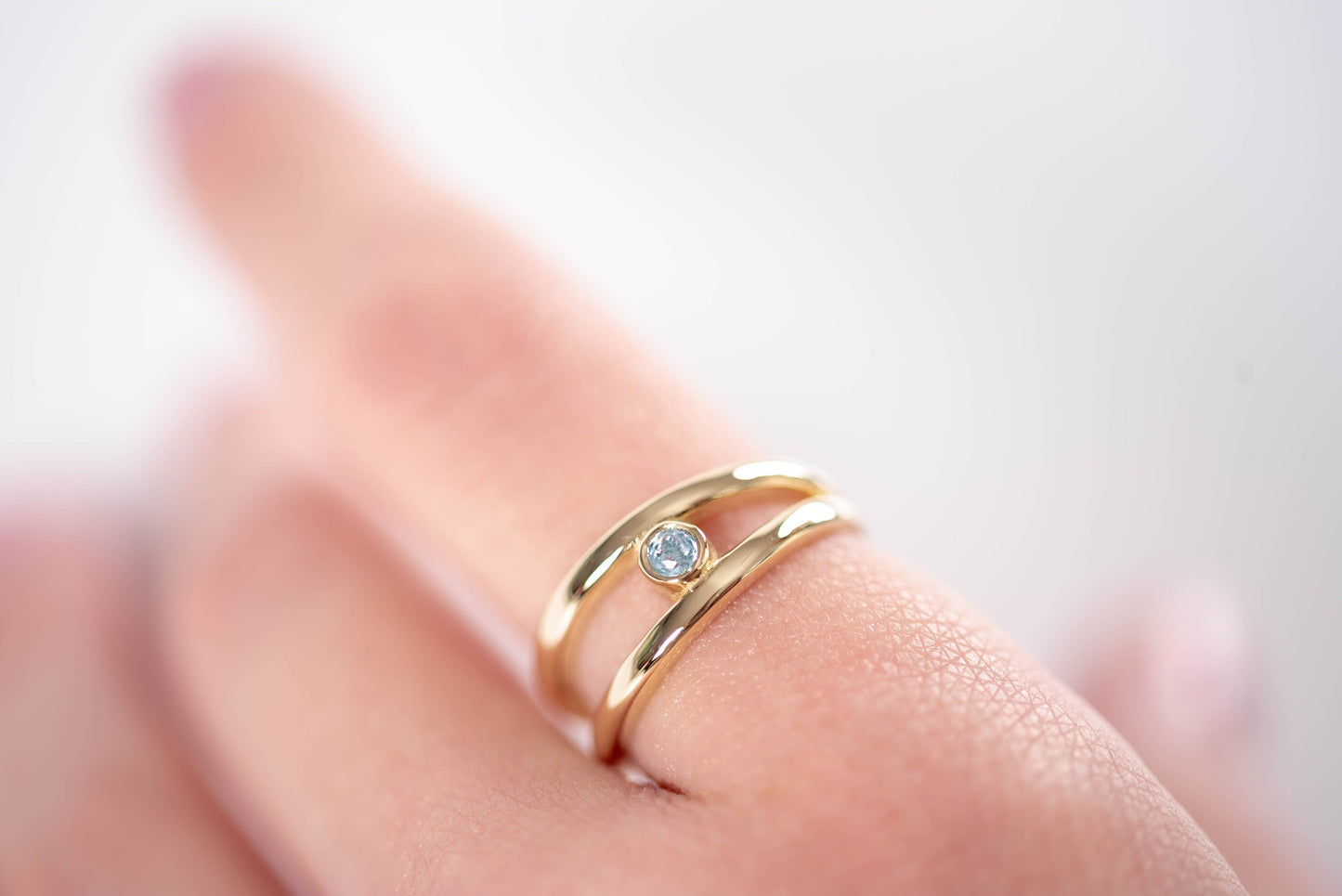 A handmade, double-row birthstone ring set in 14k gold with a bezel setting.