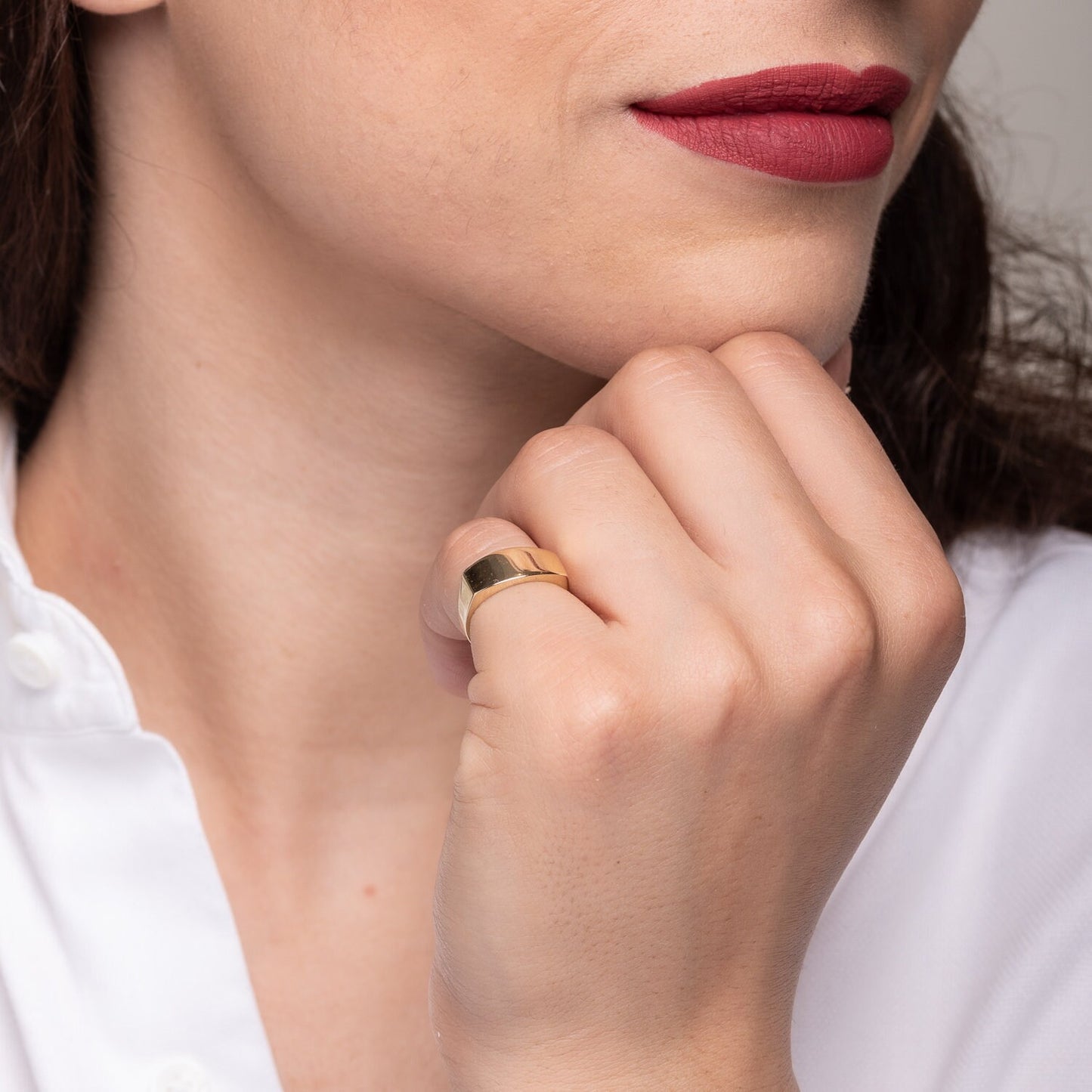 A personalized signet ring crafted in 14k gold, displayed on a model's pinky finger.