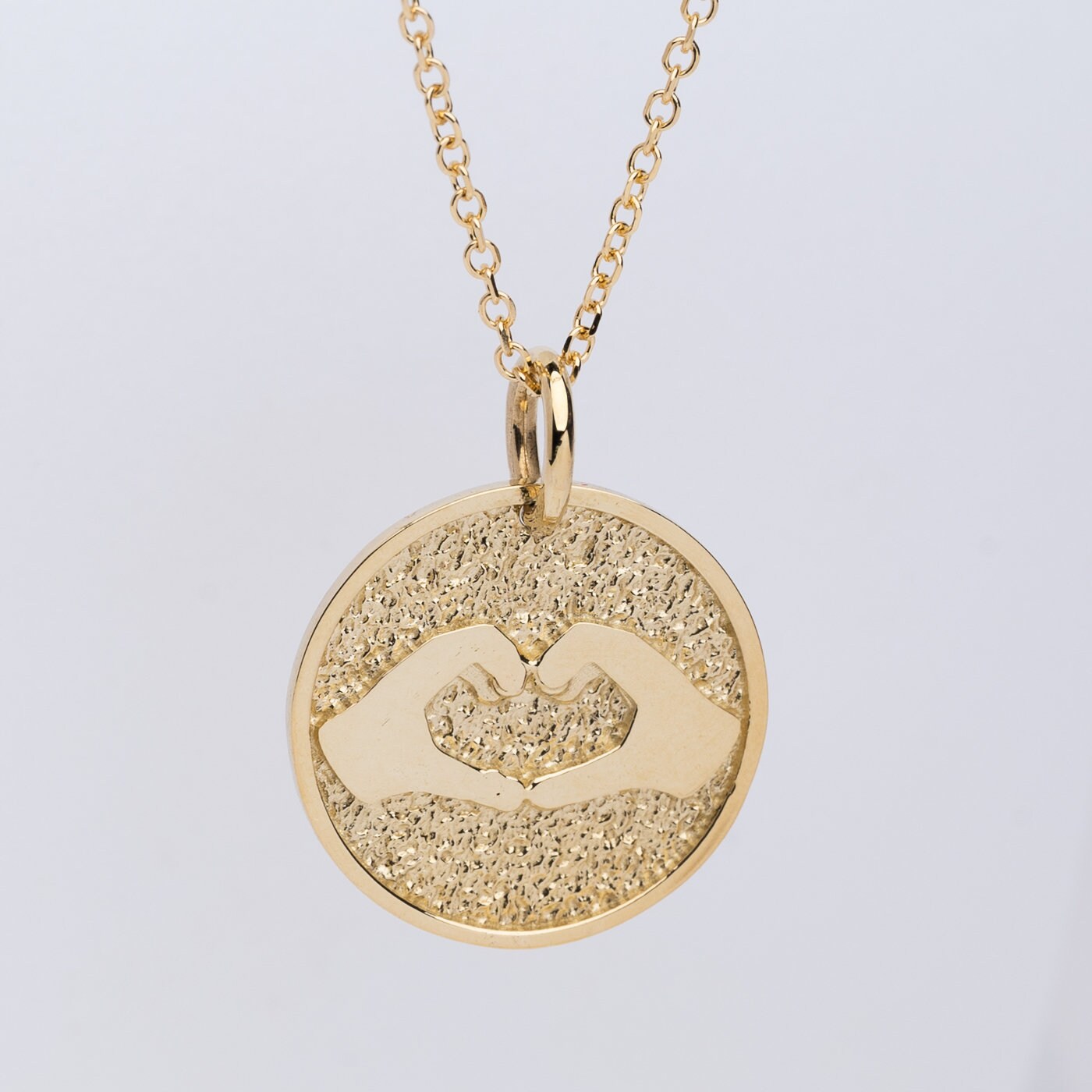 Hand Gesture Heart Necklace in 14k solid gold for women with free engraving on the back side.