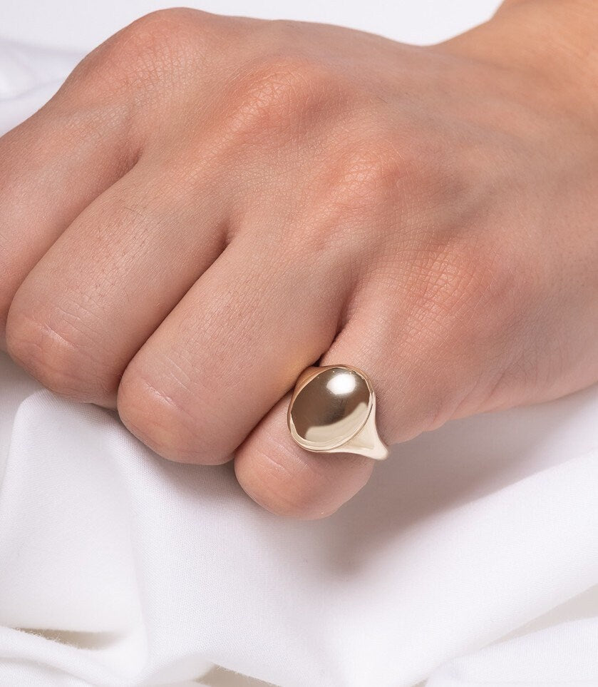 An Oval Signet Ring for women, crafted in 14k gold, featuring an engravable top surface.