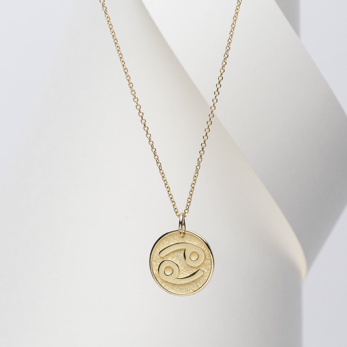 A Zodiac necklace for women, crafted in 14k gold, featuring complimentary engraving on the reverse side.