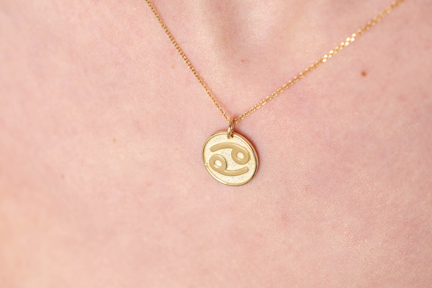 A Zodiac necklace for women, crafted in 14k gold, featuring complimentary engraving on the reverse side.