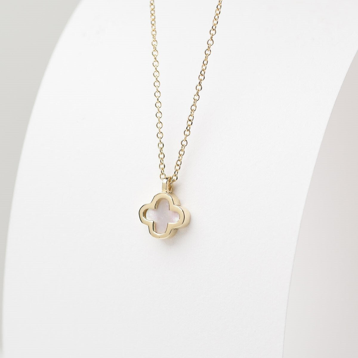 A 14k gold necklace for women, adorned with a clover-shaped mother of pearl motif.