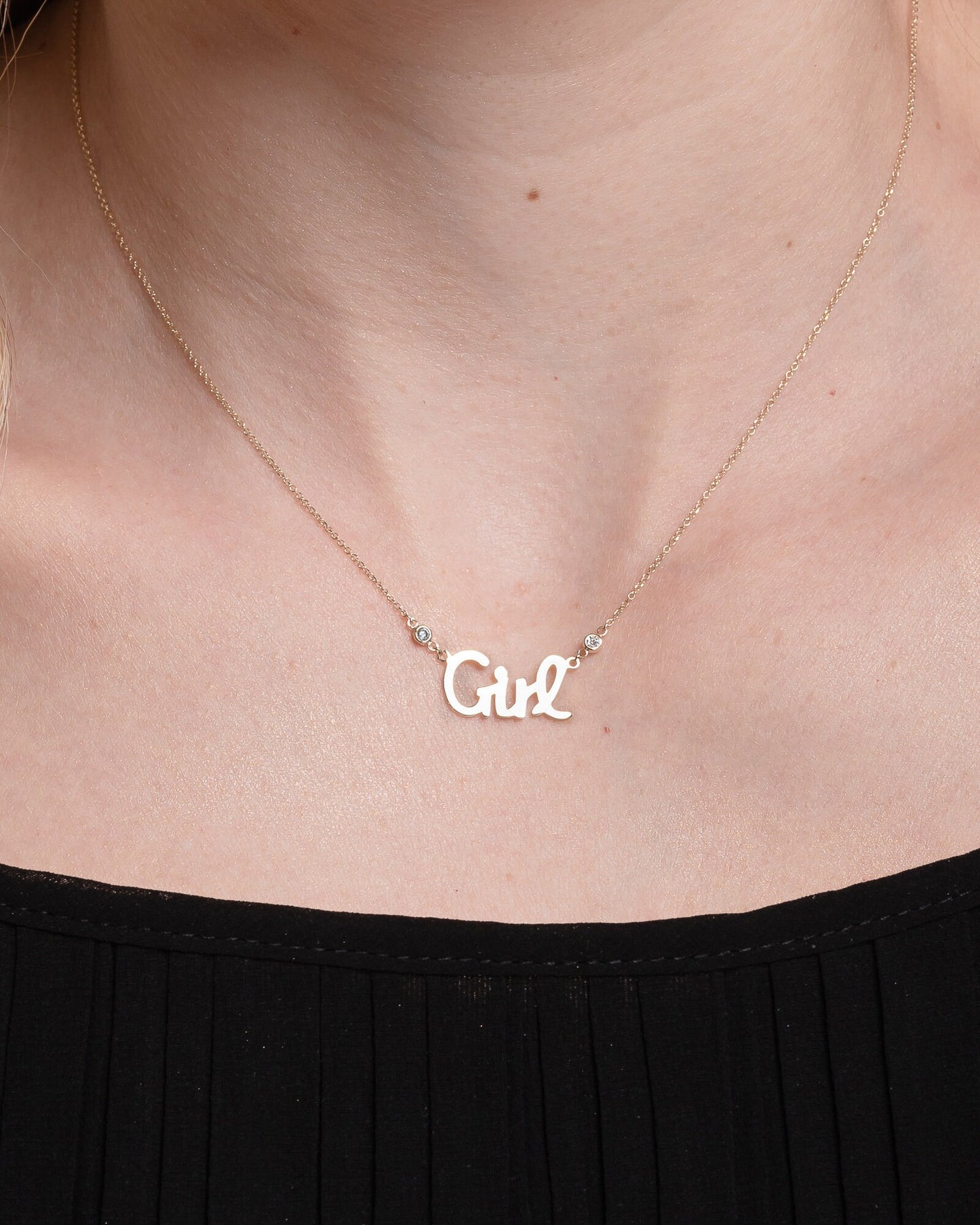 Girl Necklace in 14k gold with two cubic zirconia stones worn by a model 