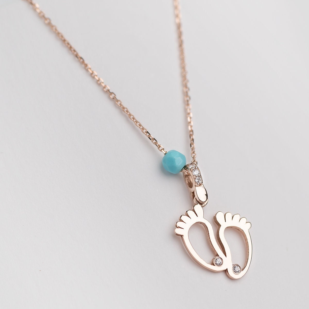 baby footprint necklace in 14k gold with cubic zirconia and turquoise stone